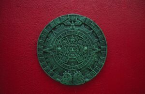 Mayan calendar decor on a vibrant red wall, symbolizing ancient Mexican culture.